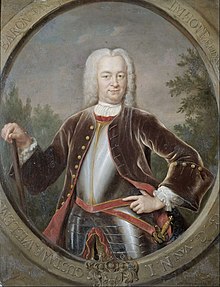 A portrait of Governor-General van Imhoff in a large white wig and black suitcoat over plate armour. He is carrying a cane in his left hand and has a sword sheathed on his right side.