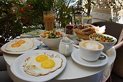 An Israeli breakfast with eggs, Israeli salad, bread and various accompaniments