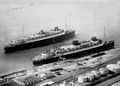 März 1930 – Die Europa (vorne am Pier) zusammen mit ihrem Schwesterschiff Bremen (hinten) in Bremerhaven