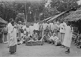 Two dancers and a group of musicians of Kulintang in Buru Regency, Maluku, Indonesia. between 1900 and 1940