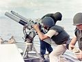 A gun crew on board USCGC Point Comfort (WPB-82317) firing an 81 mm mortar during the bombardment of a suspected Viet Cong staging area one mile behind An Thoi in August 1965