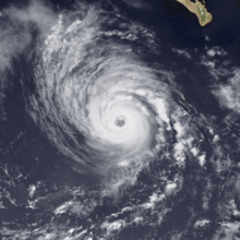 A satellite image of a hurricane over the Eastern Pacific Ocean with a clear eye and spiral bands of thick clouds