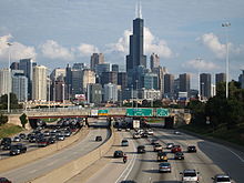 View of the Chicago skyline, including the prominent Willis Tower, with a divided highway leading towards it