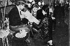 Kacar-kucur ceremony, groom pouring rice and coins into bride's scarf, c. 1960