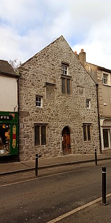 Three-story stone building with arched doorway