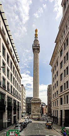 a tall stone column surrounded by buildings