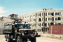 Military truck in front of building