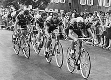 The Molteni team riding behind each other through a crowd-lined street