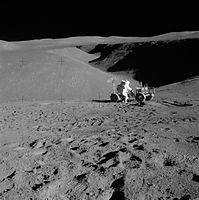 Lunar landscape with man leaning over rover