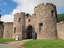A stone structure with two round towers and a gate passage in-between.