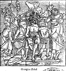 Black-and-white depiction of a man seated on a chair, with a large smouldering crown on his head. He is naked, his crotch covered with a cloth, and his hands are tied behind his hack. Two people are tearing at the flesh of his shoulders with their mouths, ne of them restrained from behind. A man is playing a pipe. The scene is crowded and set in no particular background. At least four people are seen impaled around.