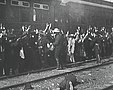 A robber holds up passengers next to a track