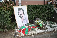 Memorial with a picture, flowers and a Basque flag