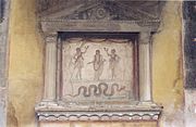 Ancestral genius (upper centre) flanked by Lares, with serpent below. Lararium, House of the Vettii Pompeii.