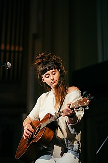 Photo of Crutchfield with great dignity playing acoustic guitar on festival stage