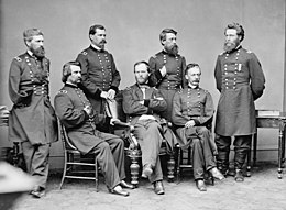Black and white photo shows 3 seated and 4 standing Union army generals. They are (l to r) seated, Logan, Sherman, and Slocum, and standing, Howard, Hazen, Davis, and Mower.