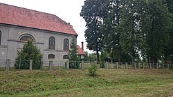 Teilansicht der Kirche in Dziurdziewo (Thalheim/Dziurdziau) – mit Storchennest im Hintergrund