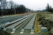 Zwi­ckau­er Stra­ße (Leip­zig), tief­lie­gen­des Ra­sen­gleis im Bau. Die Fahr­bahn­bal­ken lie­gen auf Stütz­punk­ten auf und bil­den pro Gleis zwei ne­ben­ein­an­der­lie­gen­de un­ter­ir­di­sche Brü­cken. Die Gleis­lage wird durch elas­ti­sche Bei­la­gen zwi­schen Fahr­bahn­bal­ken und Schwel­len re­gu­liert, re­gel­mä­ßi­ges Stop­fen ist nicht er­for­der­lich und auch nicht mög­lich.