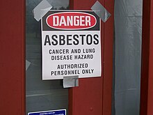 A sign reads "Danger, asbestos, cancer and lung diseaes hazard, authorized personnel only"