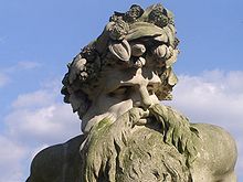 A photograph of the head and shoulders of the statue – a heavily bearded man crowned with foliage
