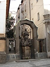 Arch with baroque statue, next to the Diamant Palace