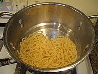 Draining the water from boiled spaghetti