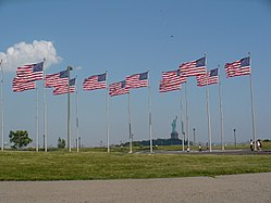 Twelve out of the 13 American Flags displayed at Liberty State Park (one flag not shown), with the Statue of Liberty in the background