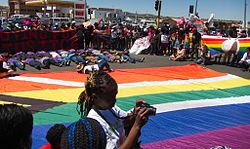 Giant flag at Soweto Pride 2012, with participants protesting against violence against lesbians