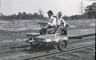 3-wheeled velocipede or handcar on a railroad track. It is operated by hand.