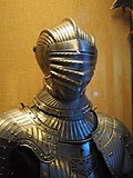 Shoulders and head of a heavily fluted suit of armour.