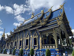 A richly ornamented Thai Buddhist temple building in striking blue and gold colours