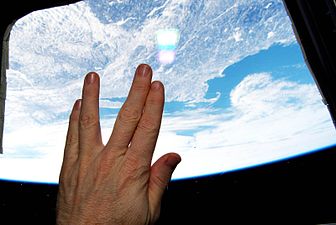 NASA astronaut Terry W. Virts performs the Vulcan salutation aboard the International Space Station on February 27, 2015, shortly after hearing of Nimoy's death. Nimoy's hometown of Boston is seen directly below.