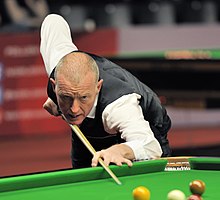 Steve Davis playing a shot at a snooker table