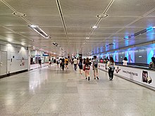 Photograph of commuters walking through the underground linkway with the travelators on the right