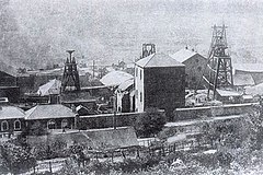 black and white photo of a coal mine and the surrounding buildings
