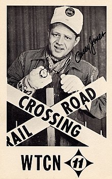 Signed publicity poster of Casey Jones behind a prop "Railroad Crossing" sign
