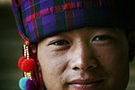 Chinese man in traditional hat of silk tartan with wool pompons, 2008