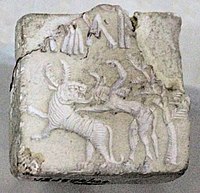 Fighting scene between a beast and a man with horns, hooves and a tail, who has been compared to the Mesopotamian bull-man Enkidu.[4][5][6] Indus Valley Civilisation seal.