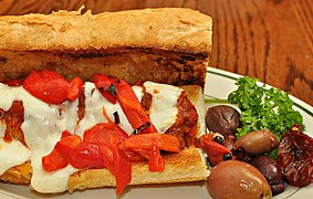 A meatball sandwich with marinara sauce, mozzarella and roasted peppers