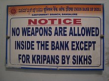 Sign reading "No weapons are allowed inside the bank except for kripans by Sikhs." "Kirpans" is misspelled as "kripans".