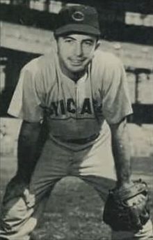 A man in a light baseball uniform and dark cap
