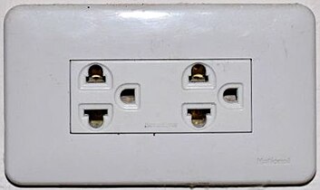 An earthed Thai socket that appears to comply with figure 4 of TIS 166-2549. Although it may accept NEMA plugs, the Thai voltage is 220 V and thus is electrically incompatible with devices designed only for 110 V.