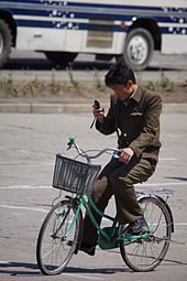 North Korean man riding a bike in Hamhung while using a cellphone.