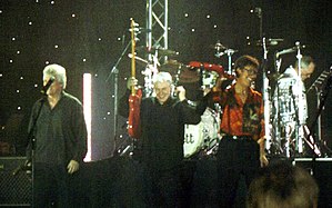 The Shadows performing in Denmark, featuring long-time members from left Bruce Welch (far left), Mark Griffiths and Hank Marvin; Brian Bennett featured in background on drums.