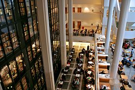 View looking down on several people working at desks; the King's Library is seen on the left