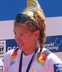 Lisa Schmidla im Nationaltrikot, die Goldmedailleist nicht im Bildausschnitt, nur das Band, an dem die Medaille befestigt ist. Ihre Sonnenbrille hat sie hochgeschoben.