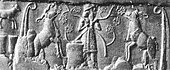 Cylinder seal impression from Uruk, showing a "king-priest" in brimmed hat and long coat feeding the herd of goddess Inanna, symbolized by two rams, framed by reed bundles as on the Uruk Vase. Late Uruk period, 3300–3000 BC.[52][53] A similar king-priest also appears standing on a ship.[54]