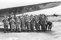 Soldiers of the 2nd Foreign Parachute Battalion standing near a transport plane in French Indochina.
