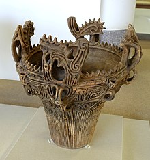 Ornately detailed clay pot in a museum