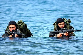 US Navy Basic Underwater Demolition-SEAL (BUD-S) students wade ashore on an Island during an exercise.